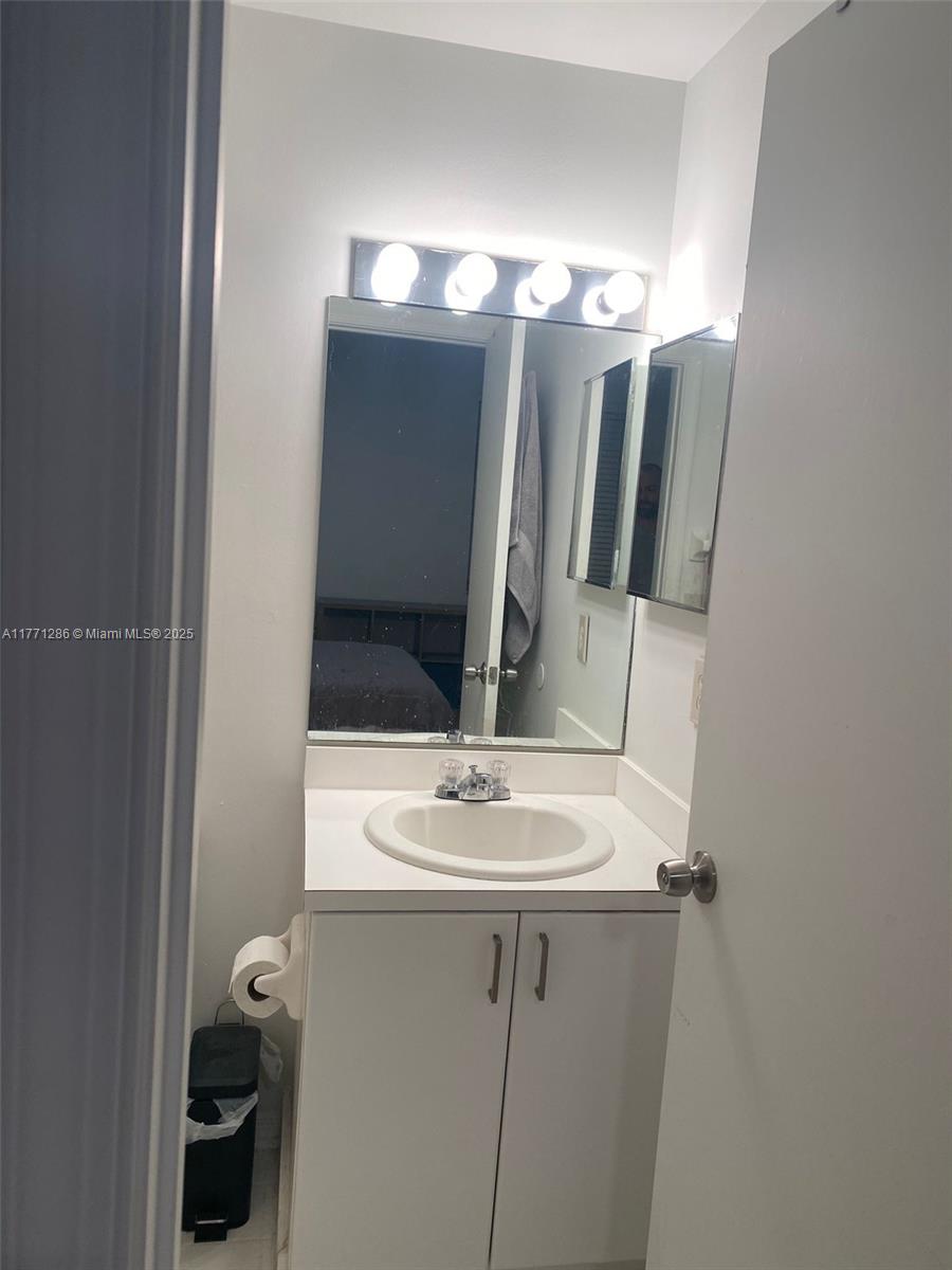 9 Whitehead Circle, Unit 9 Weston, FL 33326 - Photo 15 of 22 a bathroom with a light fixture a sink and a mirror