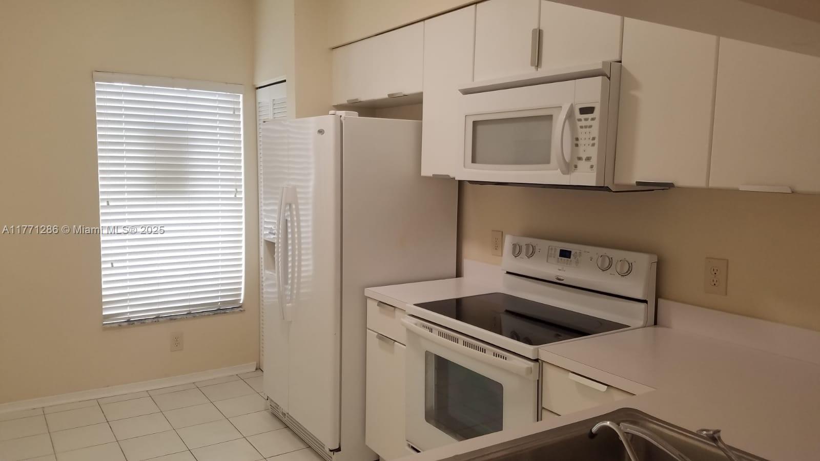 9 Whitehead Circle, Unit 9 Weston, FL 33326 - Photo 3 of 22 a view of a kitchen with white cabinets and white appliances