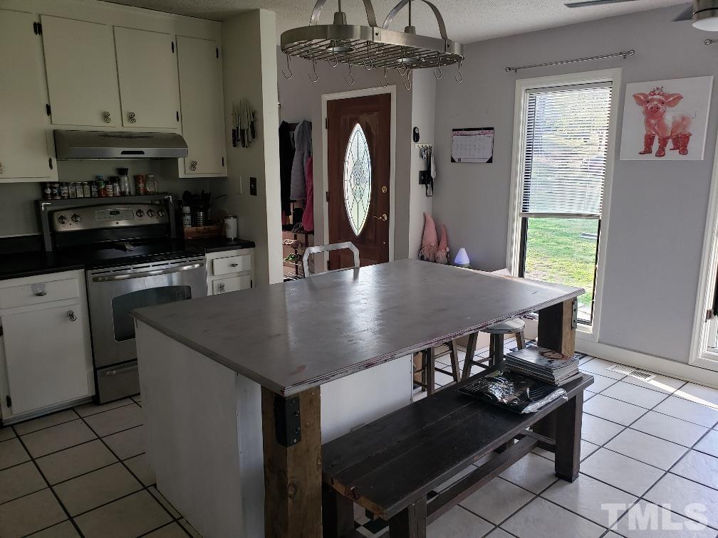 198 Pope Lake Road Angier, NC 27501 - Photo 8 of 19 a kitchen with stainless steel appliances granite countertop a stove a refrigerator a sink a dining table and chairs with wooden floor