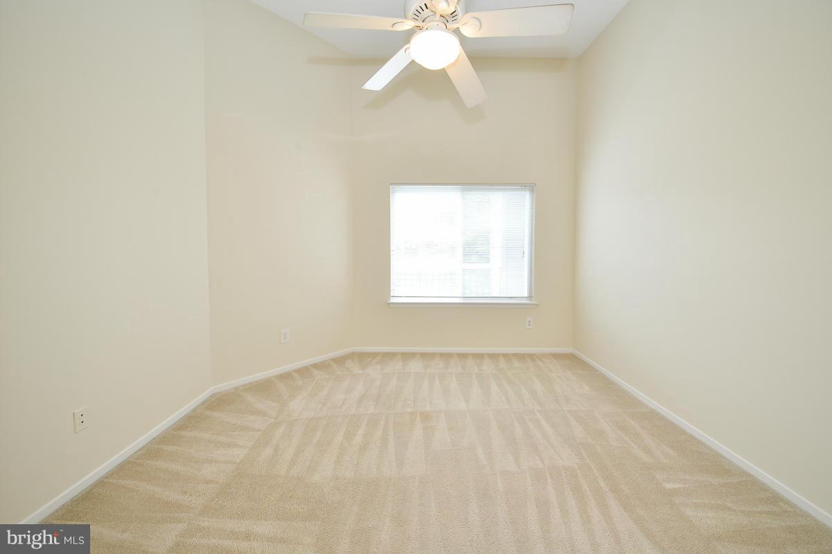 11743 Summerchase Circle, Unit B Reston, VA 20194 - Photo 13 of 24 an empty room with a window and a chandelier fan