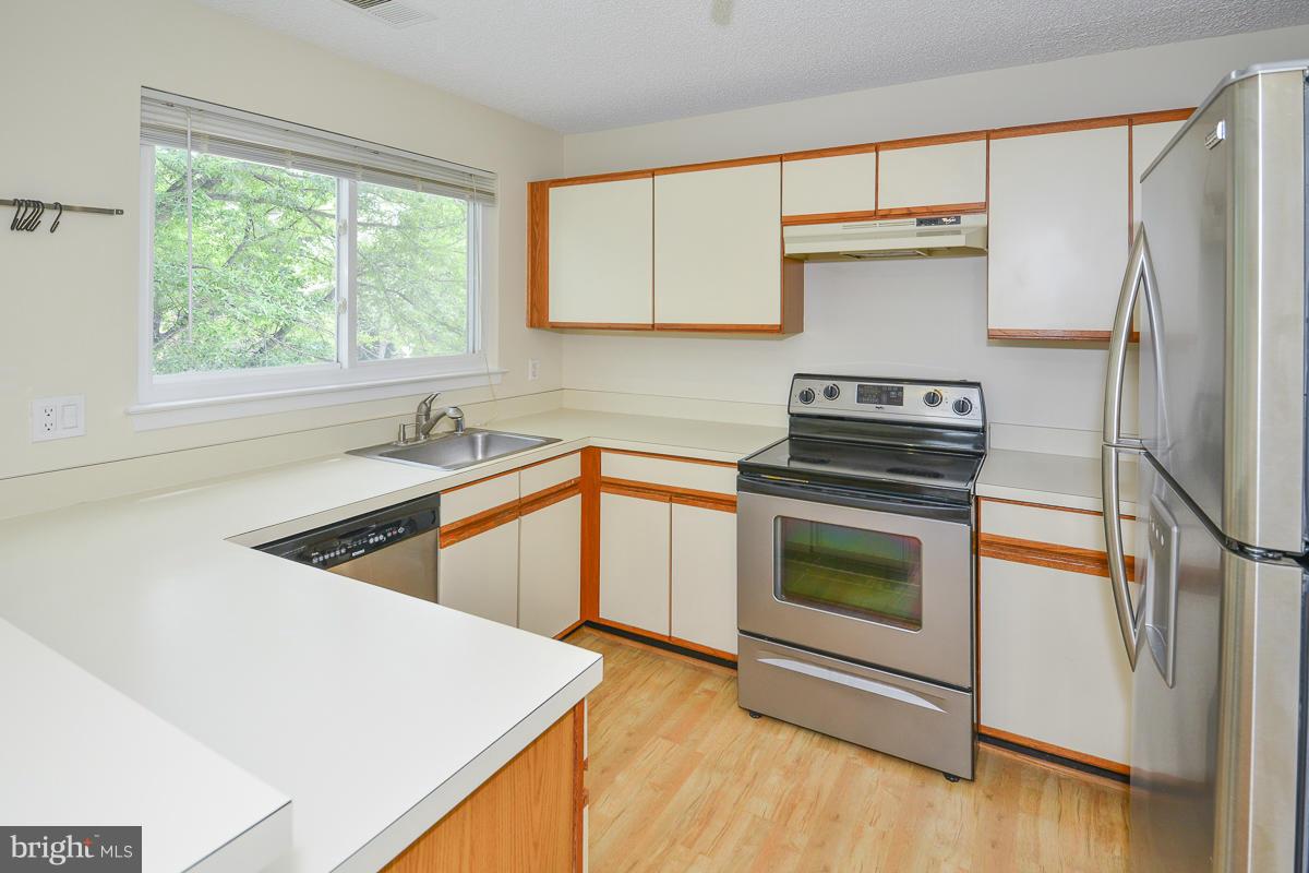 11743 Summerchase Circle, Unit B Reston, VA 20194 - Photo 7 of 24 a kitchen with a stove a sink and a refrigerator