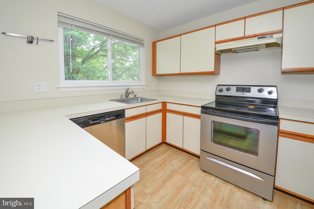 11743 Summerchase Circle, Unit B Reston, VA 20194 - Photo 8 of 24 a kitchen with a stove a sink and a microwave