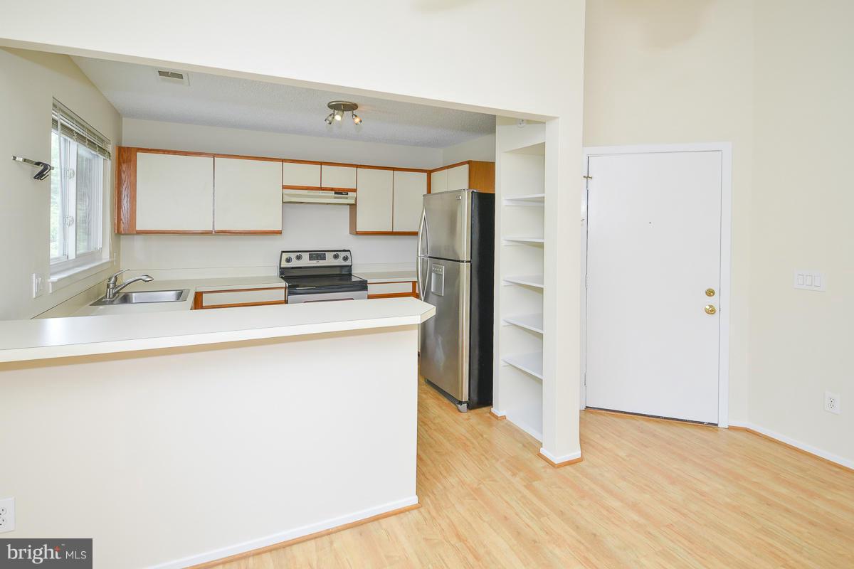 11743 Summerchase Circle, Unit B Reston, VA 20194 - Photo 9 of 24 a kitchen with stainless steel appliances a sink stove and cabinets