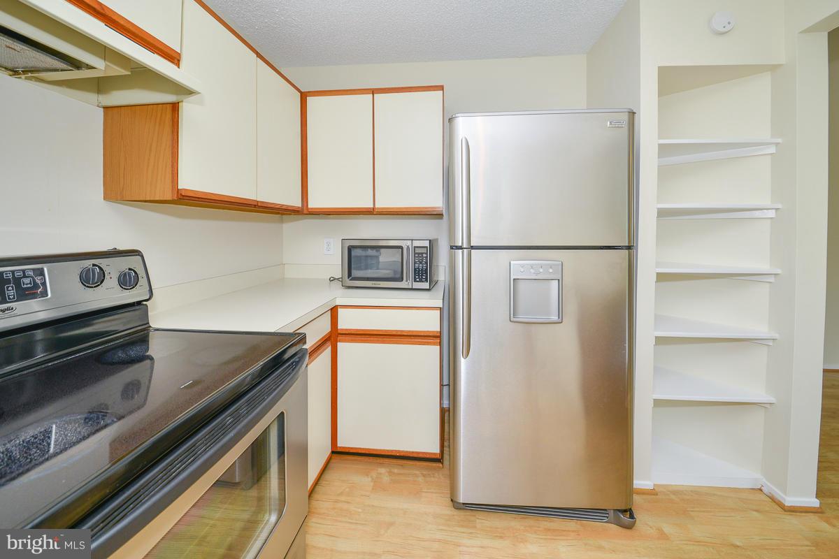 11743 Summerchase Circle, Unit B Reston, VA 20194 - Photo 10 of 24 a kitchen with a refrigerator stove and cabinets