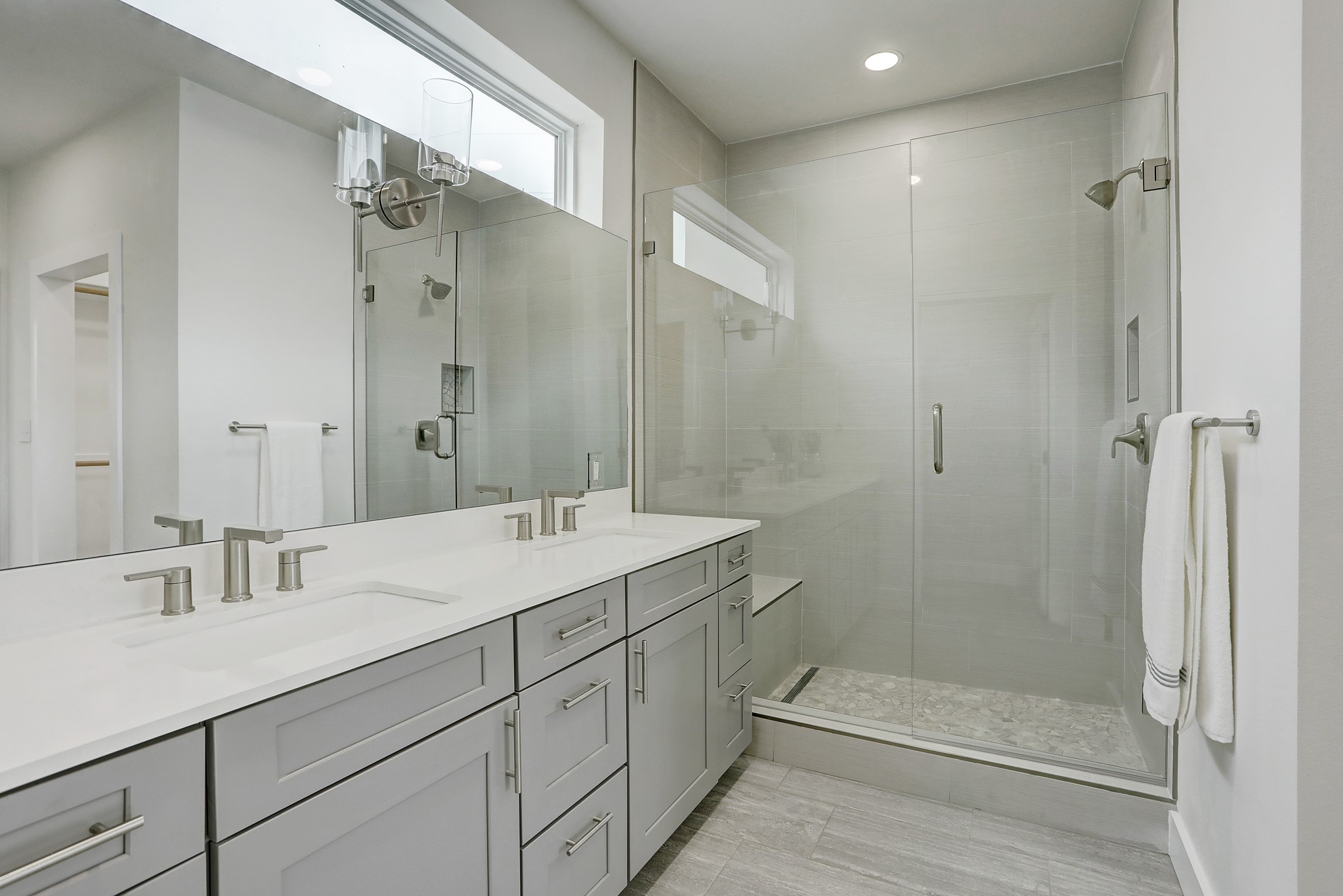 4300 Mansfield Dam Road, Unit 531 Austin, TX 78734 - Photo 21 of 32 A sleek double vanity sits beside a modern glass-enclosed shower with tiled flooring.