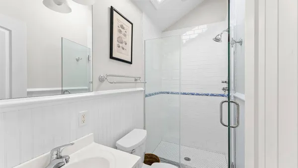 a bathroom with a granite countertop sink mirror vanity and toilet