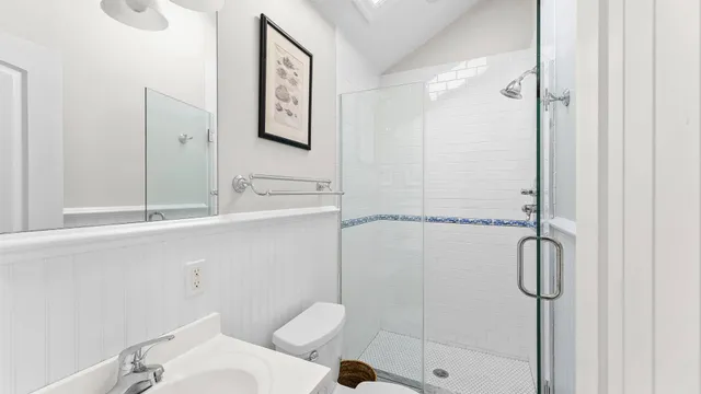 a bathroom with a granite countertop sink mirror vanity and toilet
