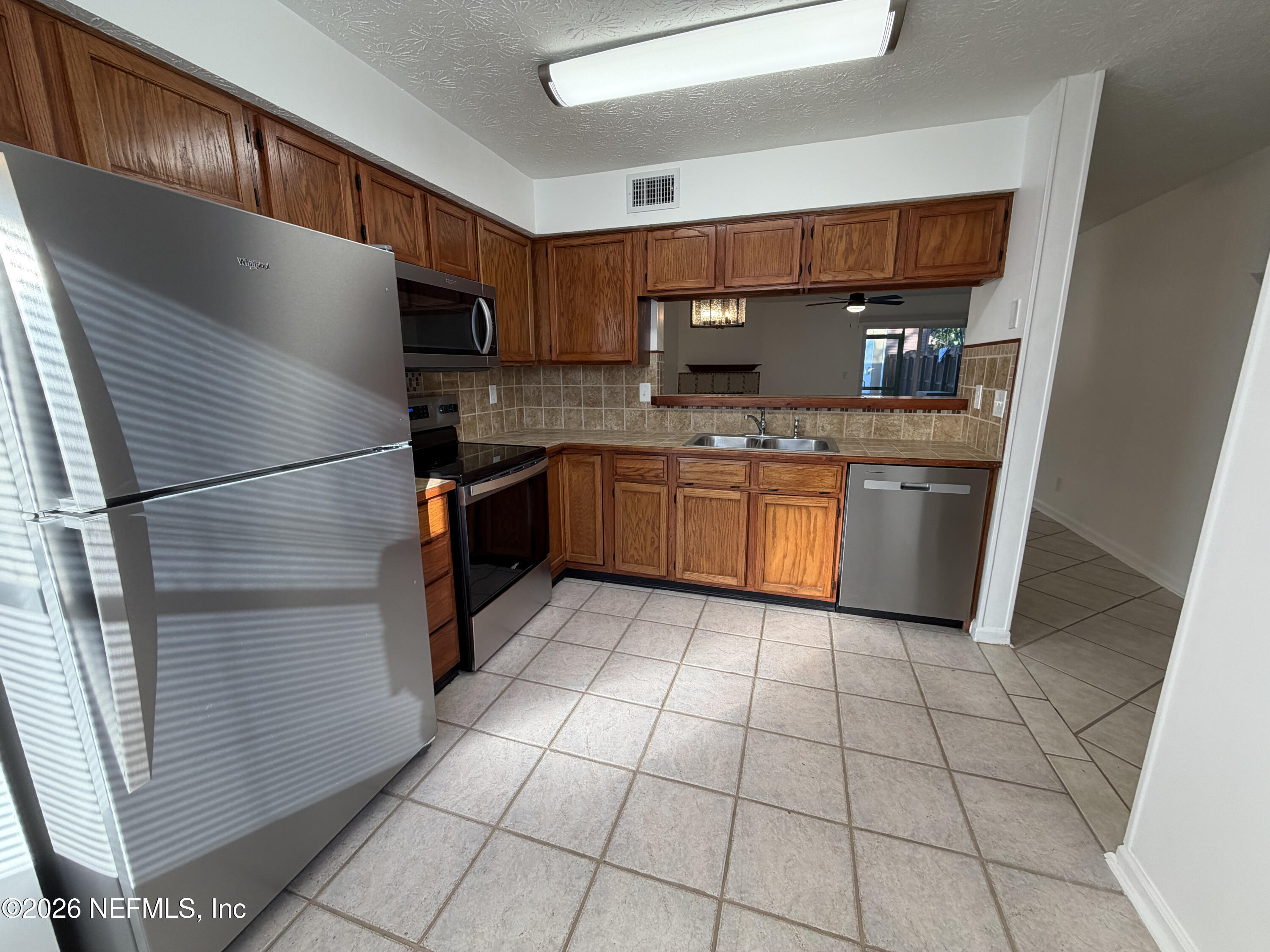 1915 Main Street Atlantic Beach, FL 32233 - Photo 3 of 19 a kitchen with stainless steel appliances granite countertop a sink stove and refrigerator
