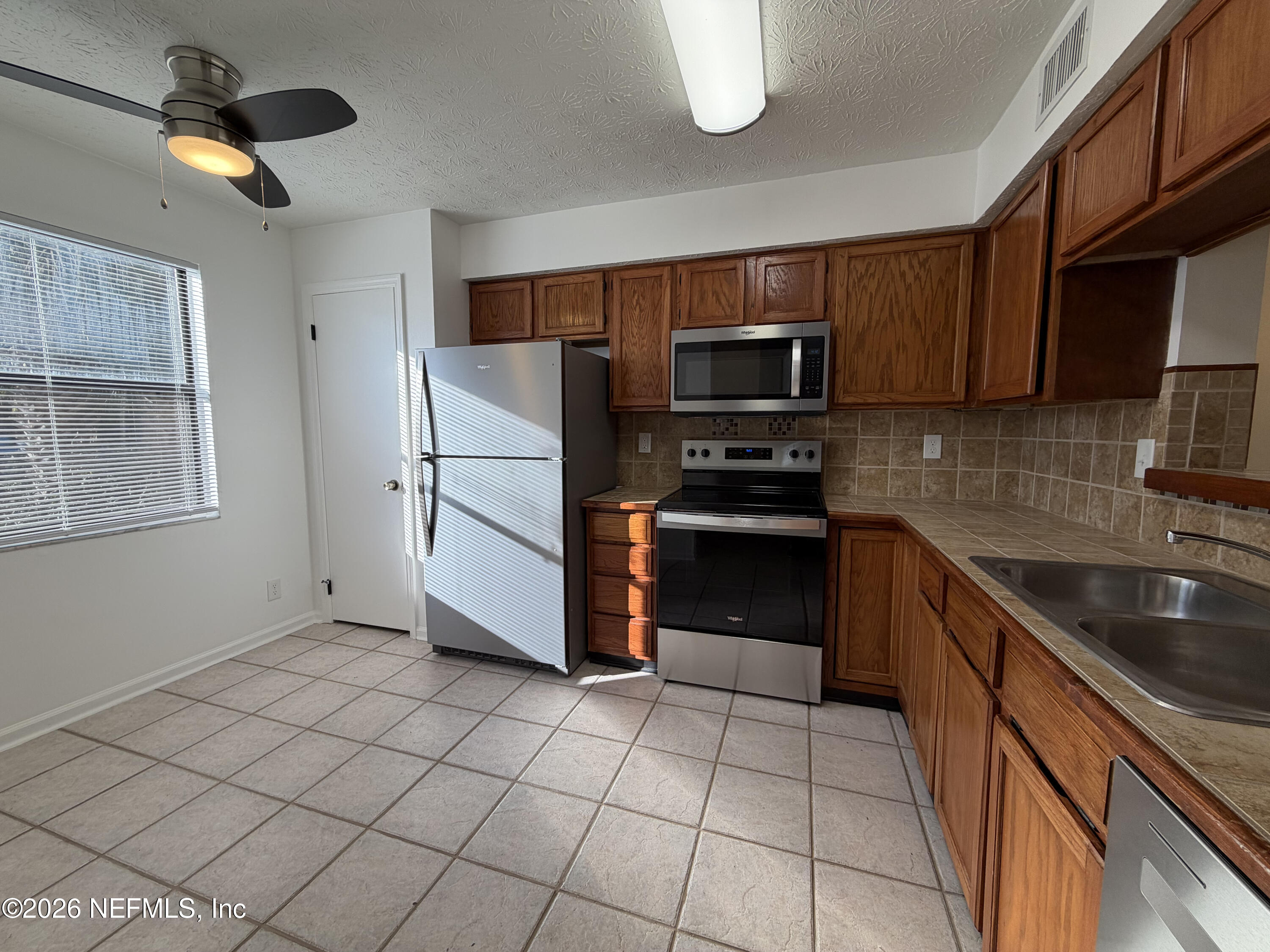 1915 Main Street Atlantic Beach, FL 32233 - Photo 4 of 19 a kitchen with stainless steel appliances granite countertop a sink a stove a microwave and cabinets