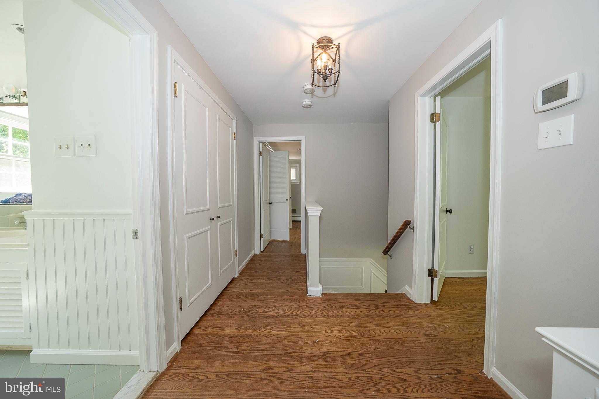 820 Milmar Road Newtown Square, PA 19073 - Photo 13 of 32 a view of a hallway with wooden floor and a bathroom