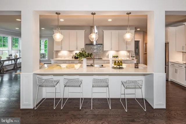 a kitchen with a dining table chairs and wooden floor