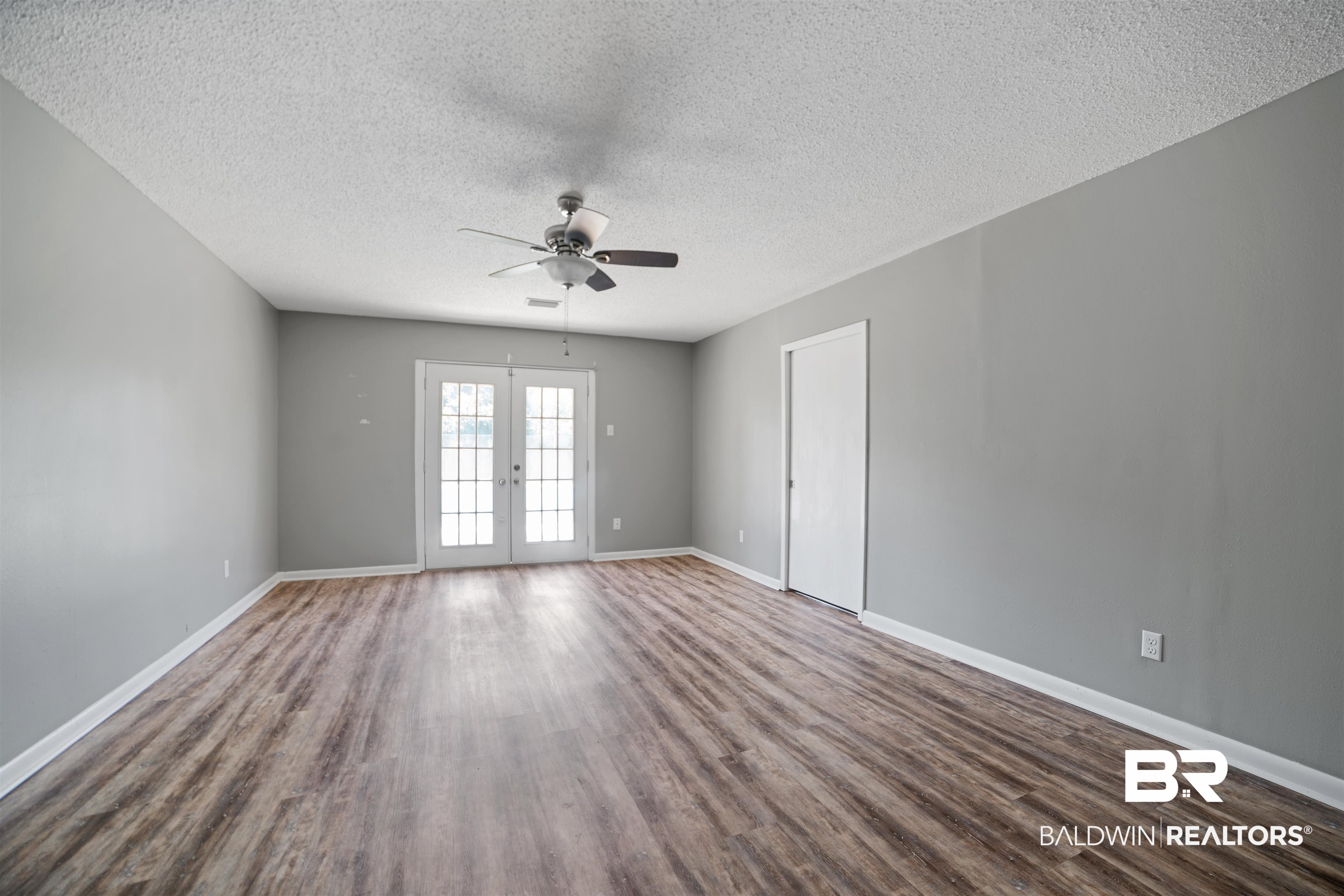 804 Regents Drive West Mobile, AL 36609 - Photo 18 of 35 Spare room with ceiling fan, french doors, a textured ceiling, and dark wood-style flooring