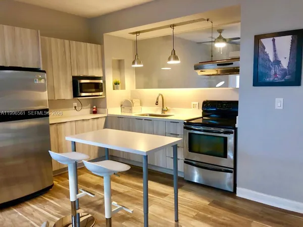 a kitchen with kitchen island granite countertop wooden cabinets and stainless steel appliances