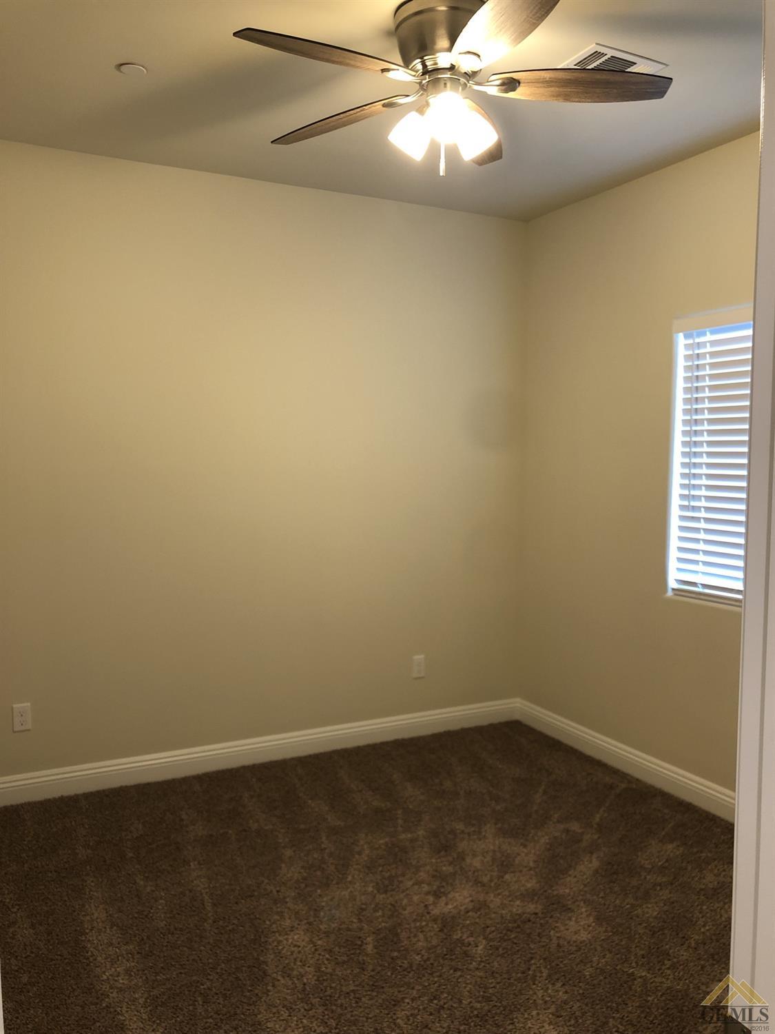 Undisclosed Address Wasco, CA 93280 - Photo 8 of 9 an empty room with a window and chandelier fan