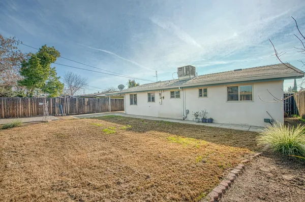 a view of a house with backyard and wooden fence