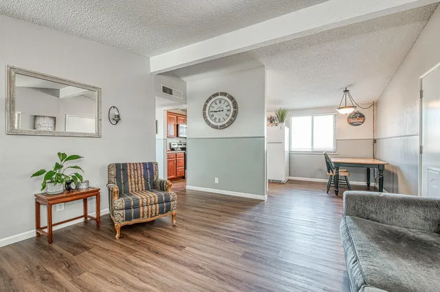 a living room with furniture and a wooden floor