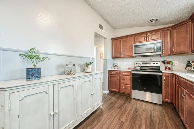 a kitchen with granite countertop white cabinets and white appliances