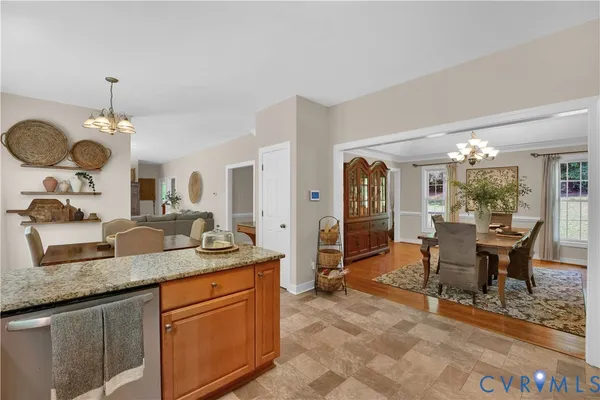 a dining hall with granite countertop a sink dishwasher a dining table and chairs with wooden floor