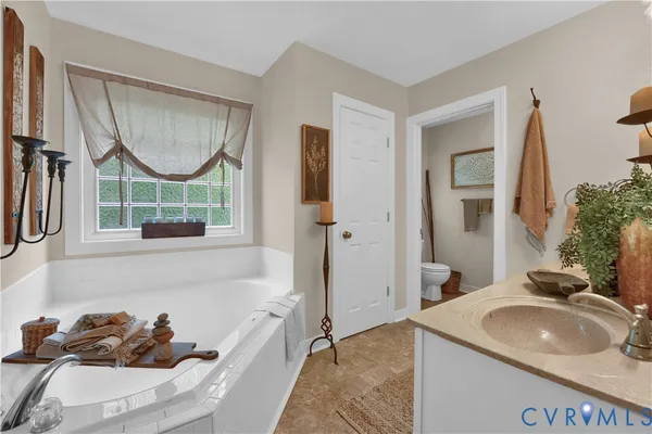 a bathroom with a tub sink and mirror