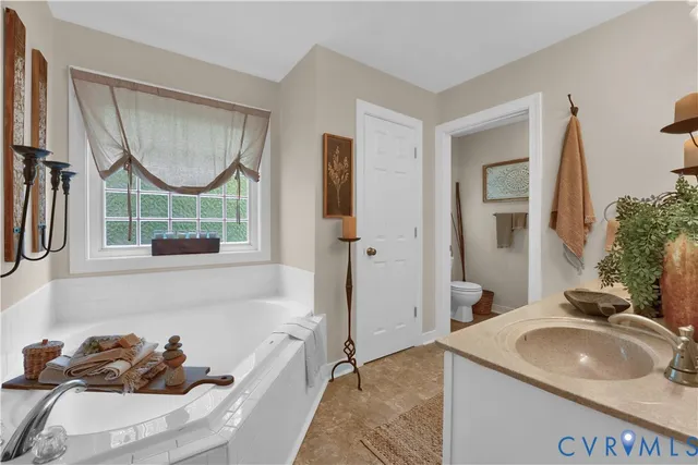a bathroom with a tub sink and mirror