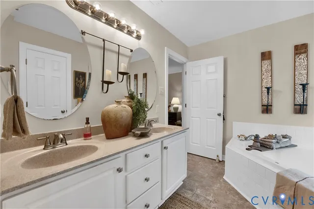 a bathroom with a granite countertop double vanity sink and mirror