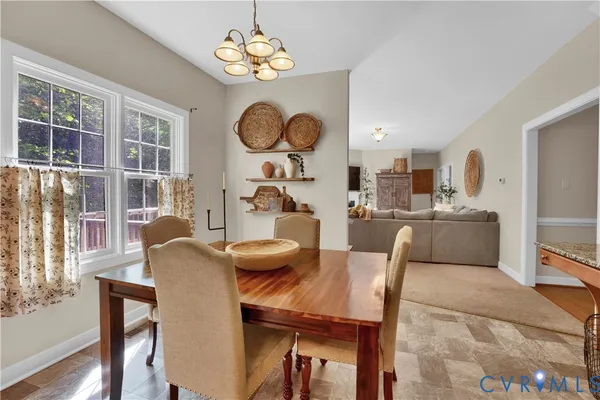 a view of a dining room with furniture a chandelier and wooden floor