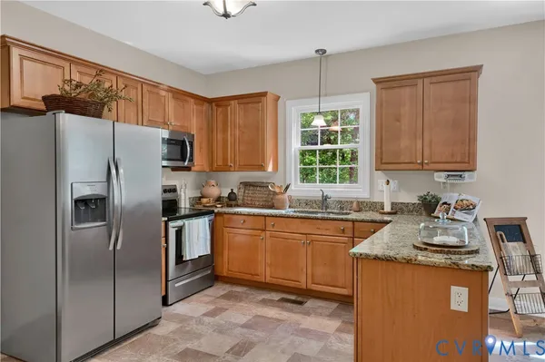 a kitchen with stainless steel appliances granite countertop a refrigerator stove and sink
