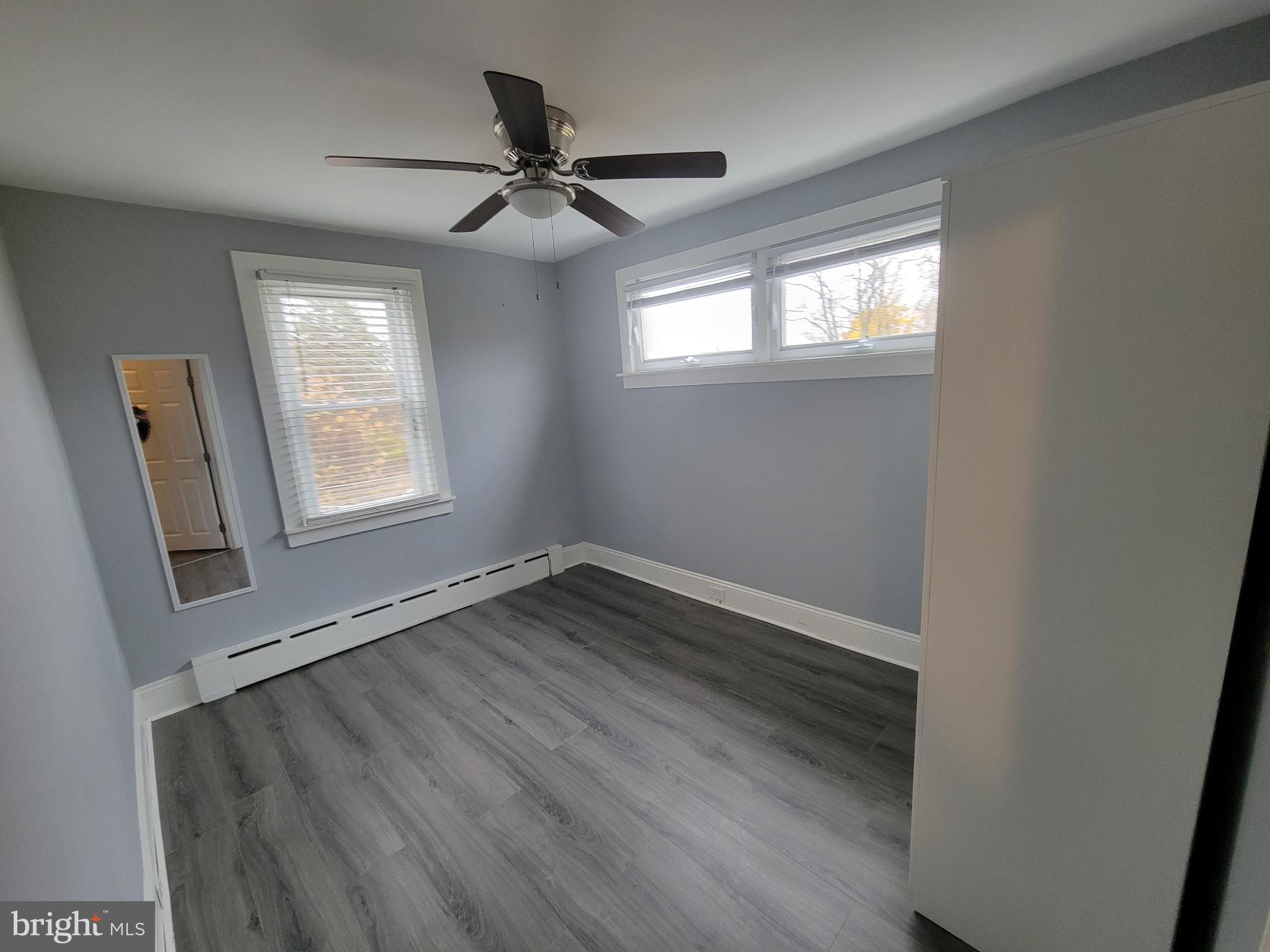 1101 Wilson Drive Havertown, PA 19083 - Photo 17 of 26 a view of an empty room with wooden floor and a window