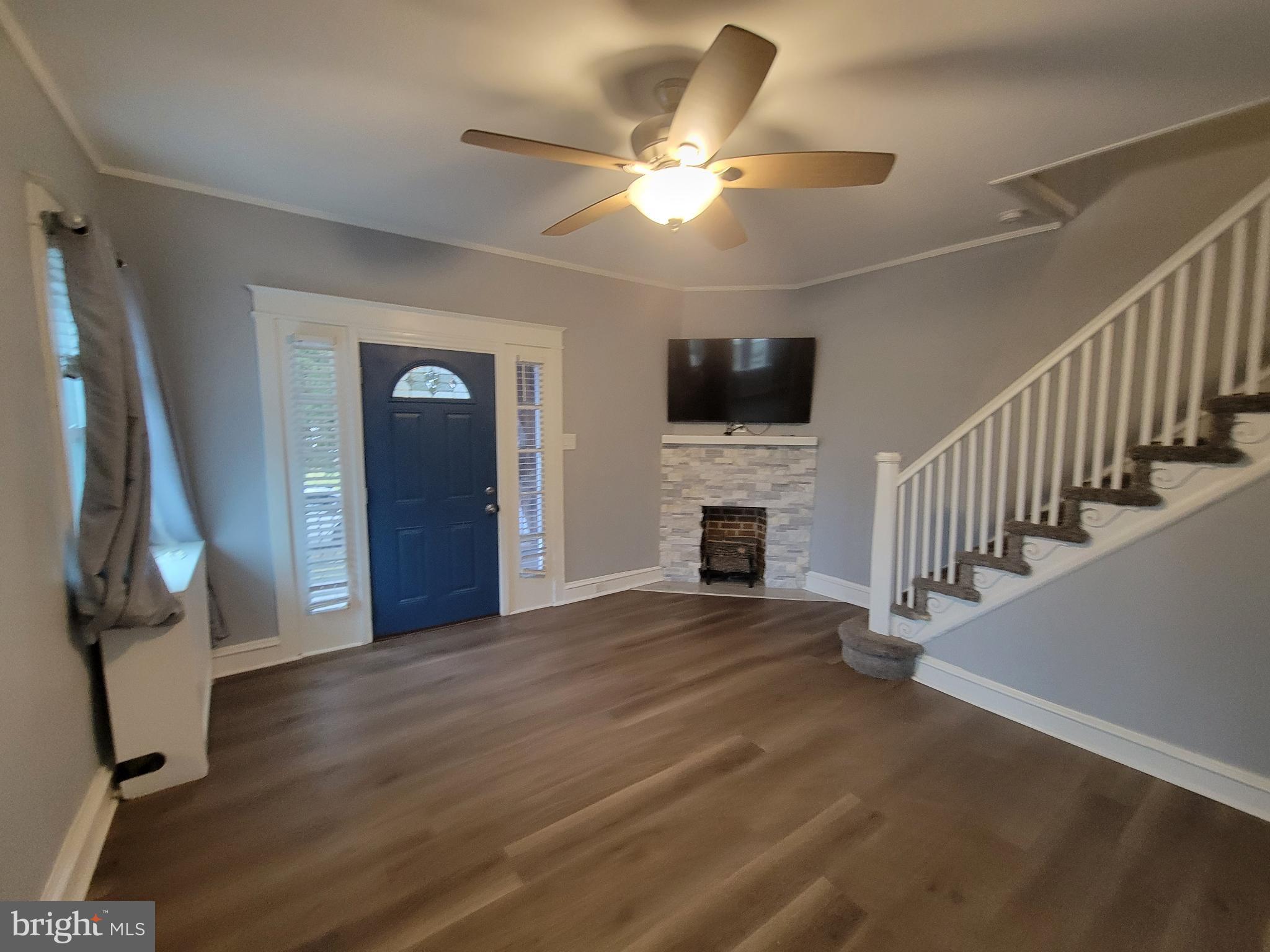 1101 Wilson Drive Havertown, PA 19083 - Photo 21 of 26 a view of a livingroom with a fireplace a ceiling fan and stairs