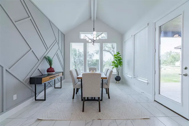 a dining room with furniture and a potted plant