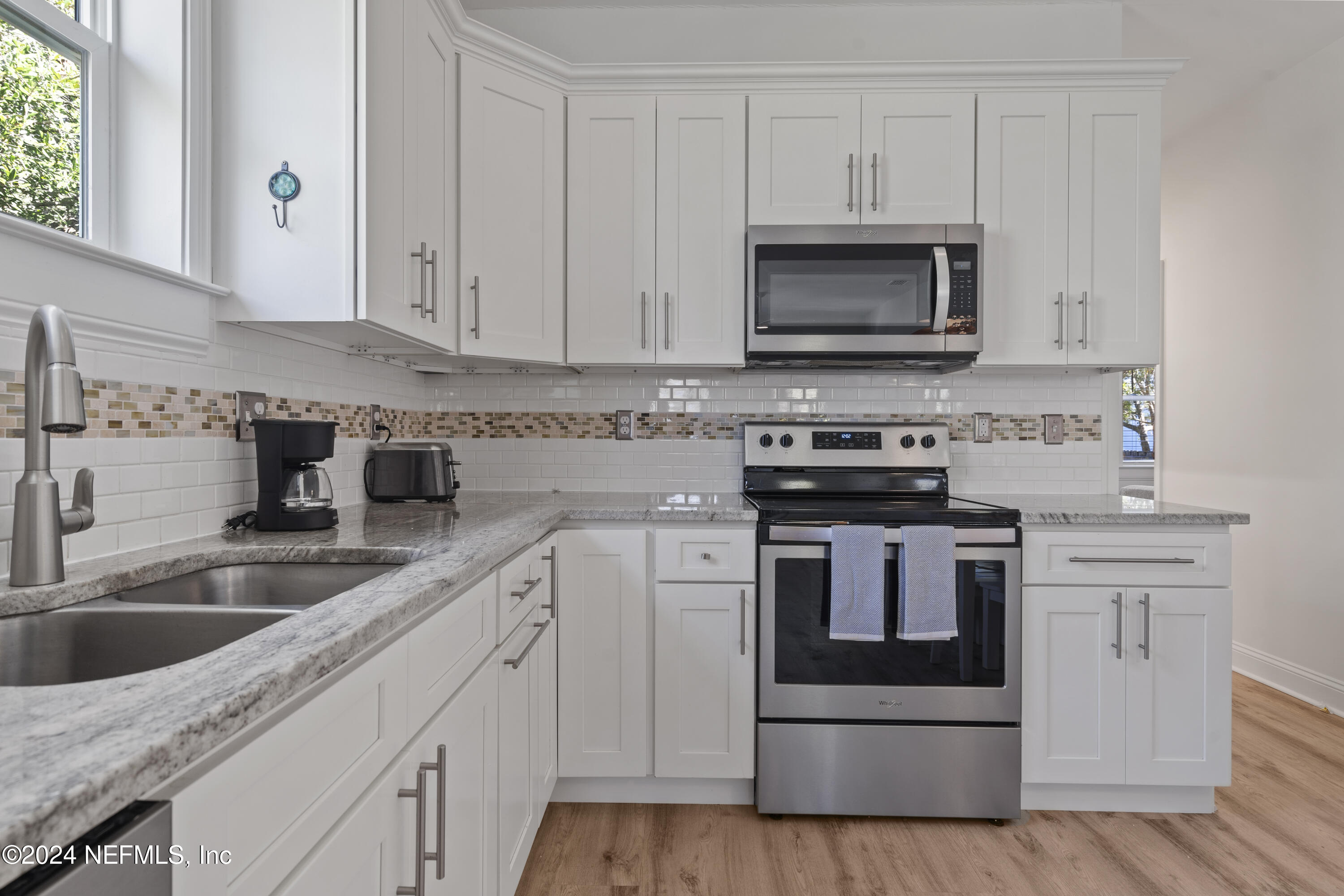 249 Riberia Street St. Augustine, FL 32084 - Photo 14 of 36 a kitchen with white cabinets and a stove top oven