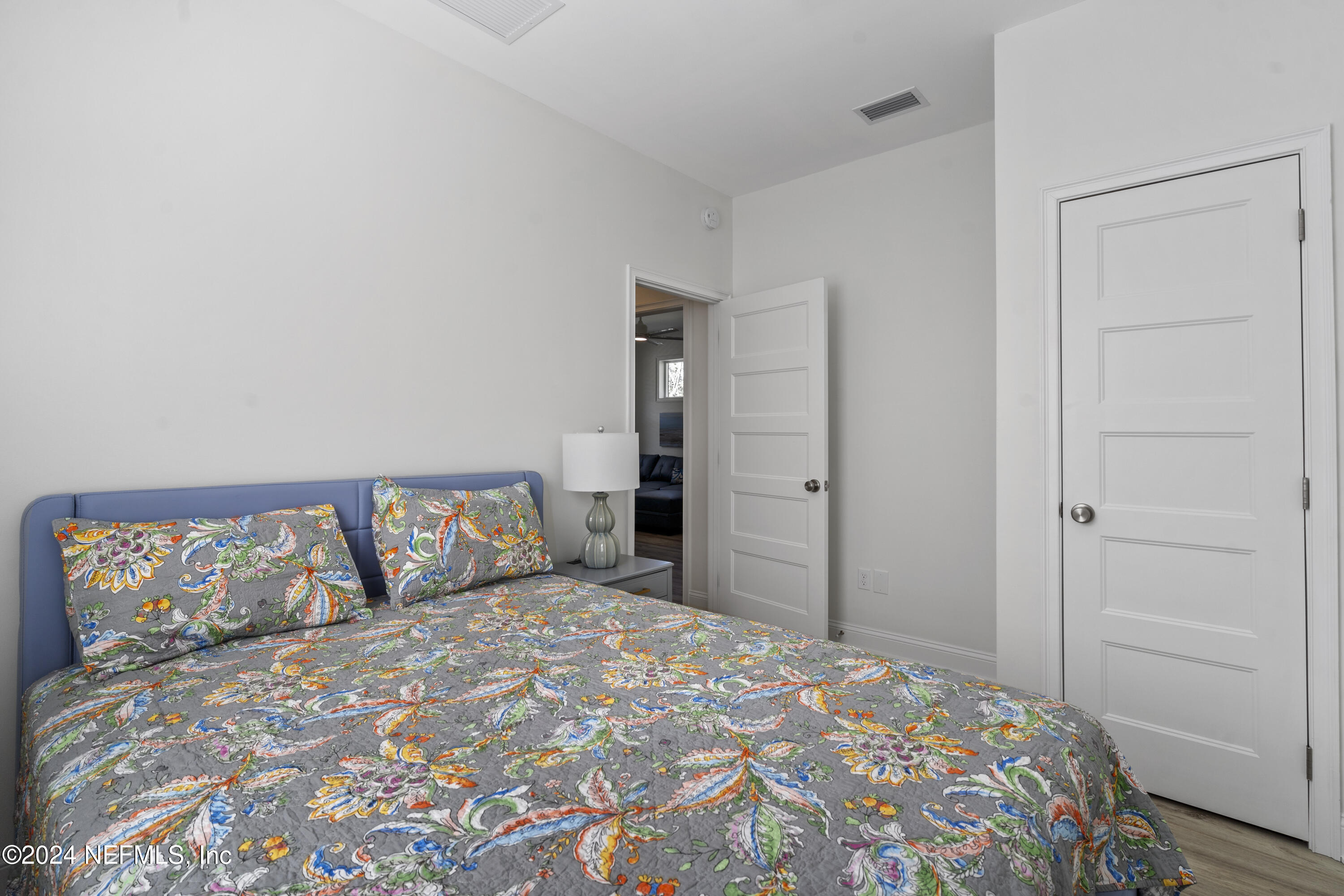 249 Riberia Street St. Augustine, FL 32084 - Photo 22 of 36 a bedroom with a large bed and a chandelier
