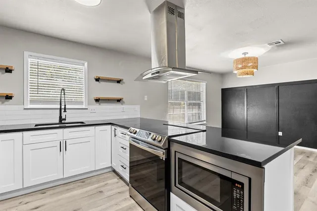 a kitchen with stainless steel appliances granite countertop a sink and a stove