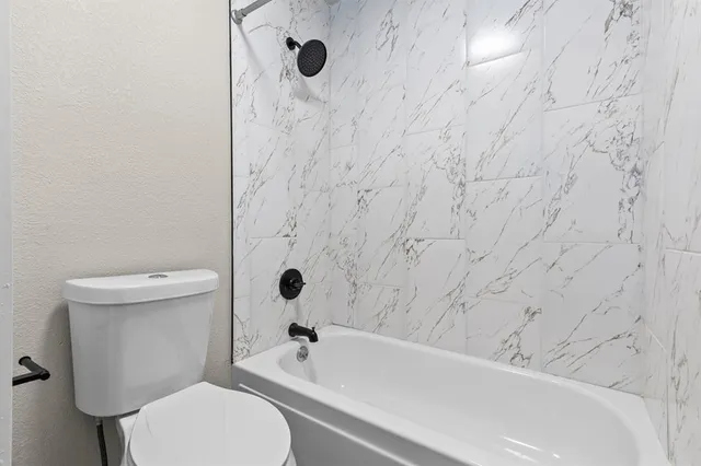 a bathroom with a toilet and a bathtub