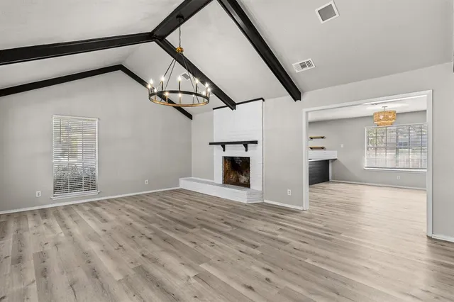 a view of empty room with wooden floor and fireplace