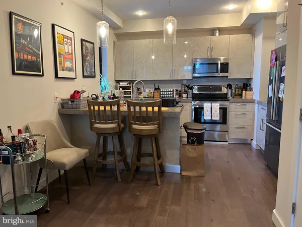 a kitchen with stainless steel appliances a dining table and chairs