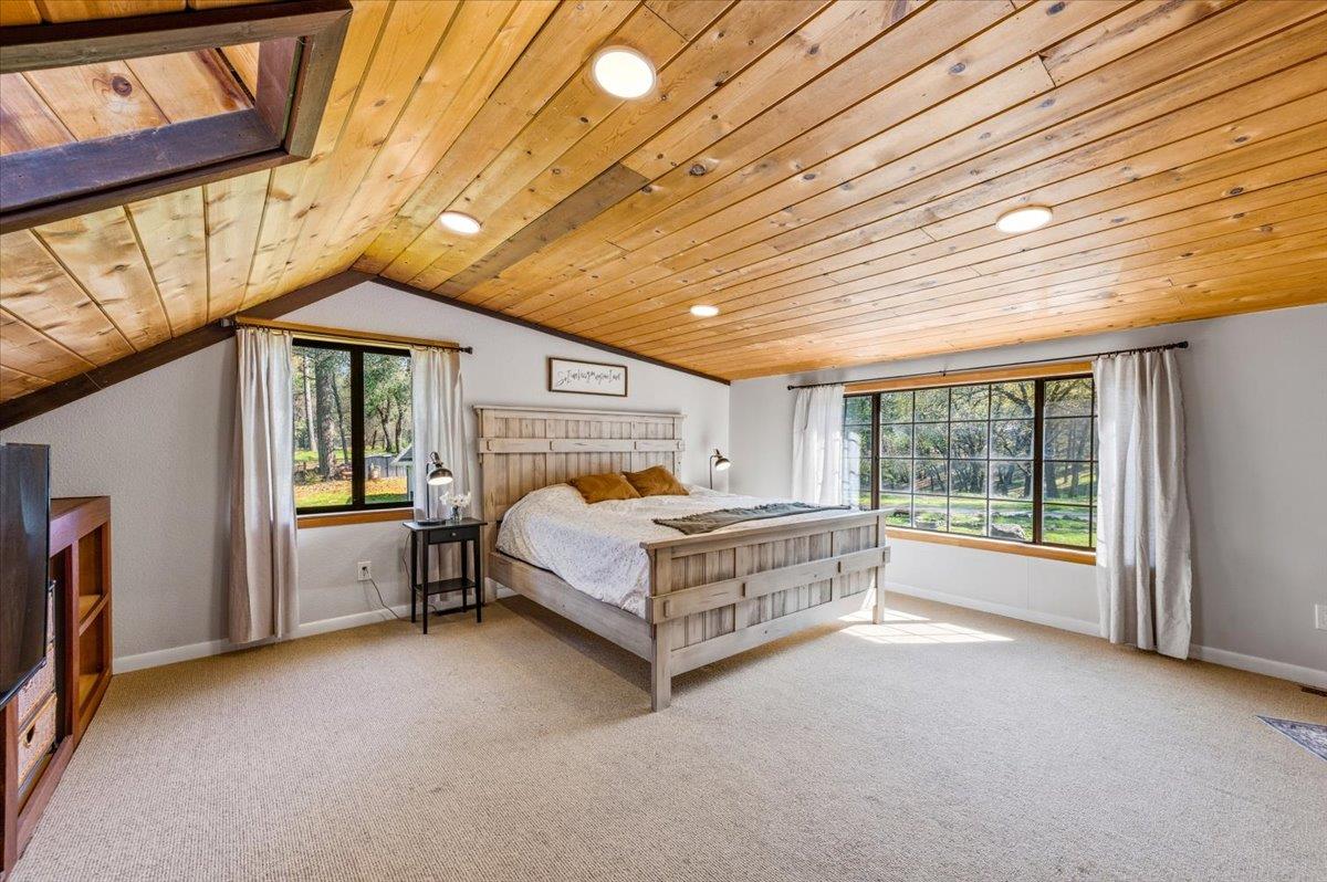 11403 Woodacre Road Grass Valley, CA 95949 - Photo 27 of 69 a bed sitting in a spacious bedroom next to a window