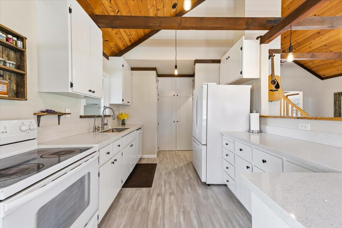11403 Woodacre Road Grass Valley, CA 95949 - Photo 8 of 69 a kitchen with granite countertop a white refrigerator oven a sink dishwasher and white cabinets with wooden floor