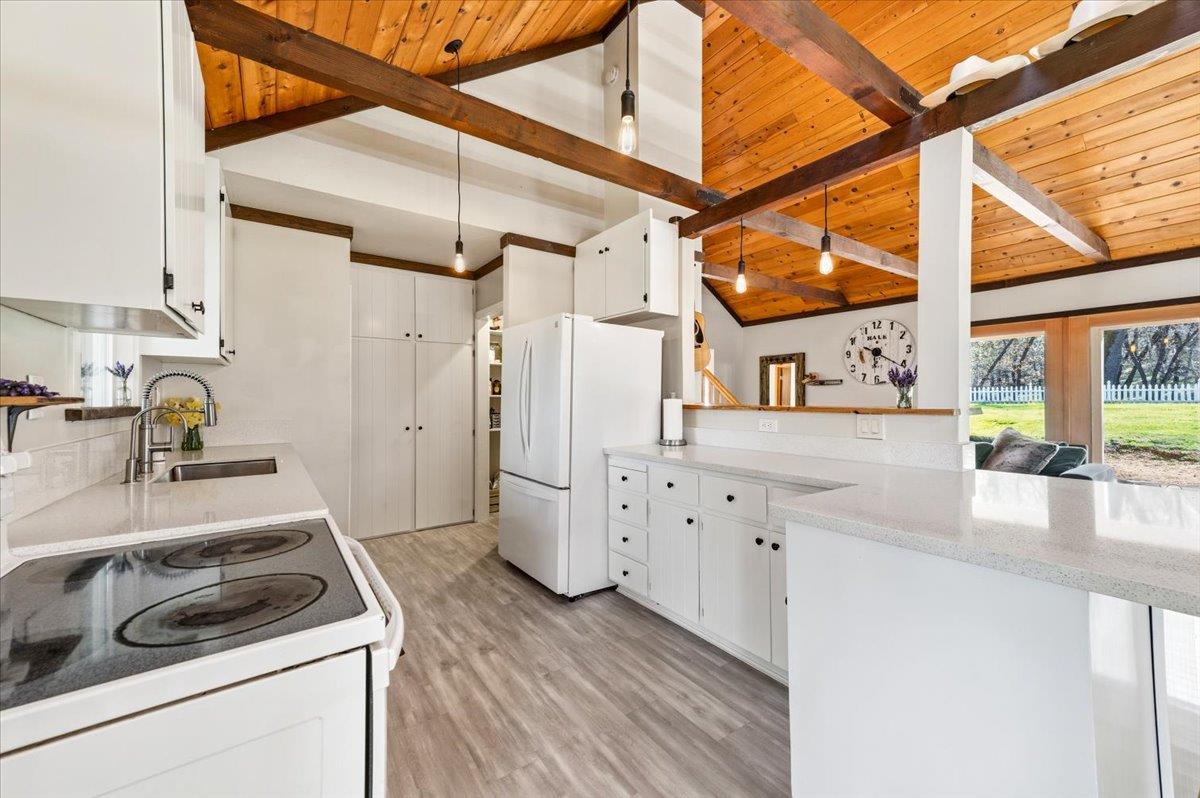 11403 Woodacre Road Grass Valley, CA 95949 - Photo 9 of 69 a kitchen that has a stove and a white wooden cabinets