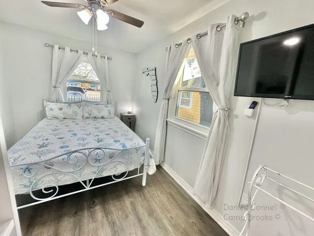 a bedroom with a bed and a flat tv screen on dresser