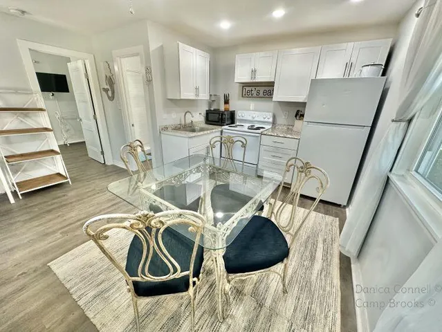 a view of a kitchen with furniture and wooden floor