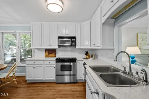 a kitchen with a sink dishwasher a refrigerator and cabinets