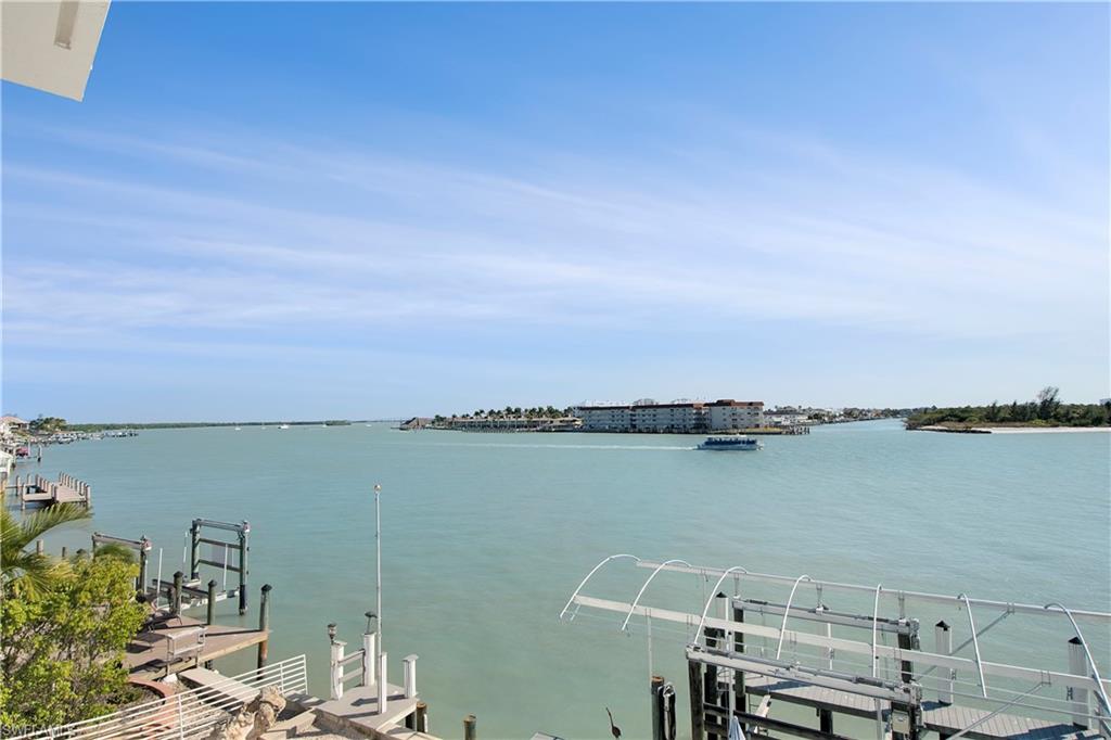 28 West Pelican Street Naples, FL 34113 - Photo 16 of 50 a view of a chair and table in wooden floor