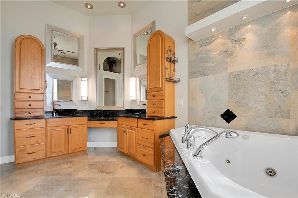 28 West Pelican Street Naples, FL 34113 - Photo 20 of 50 a bathroom with a tub sink and mirror