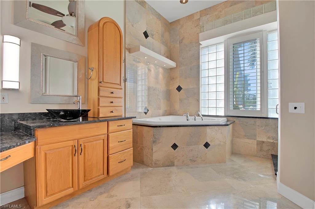 28 West Pelican Street Naples, FL 34113 - Photo 21 of 50 a bathroom with a granite countertop sink and a mirror