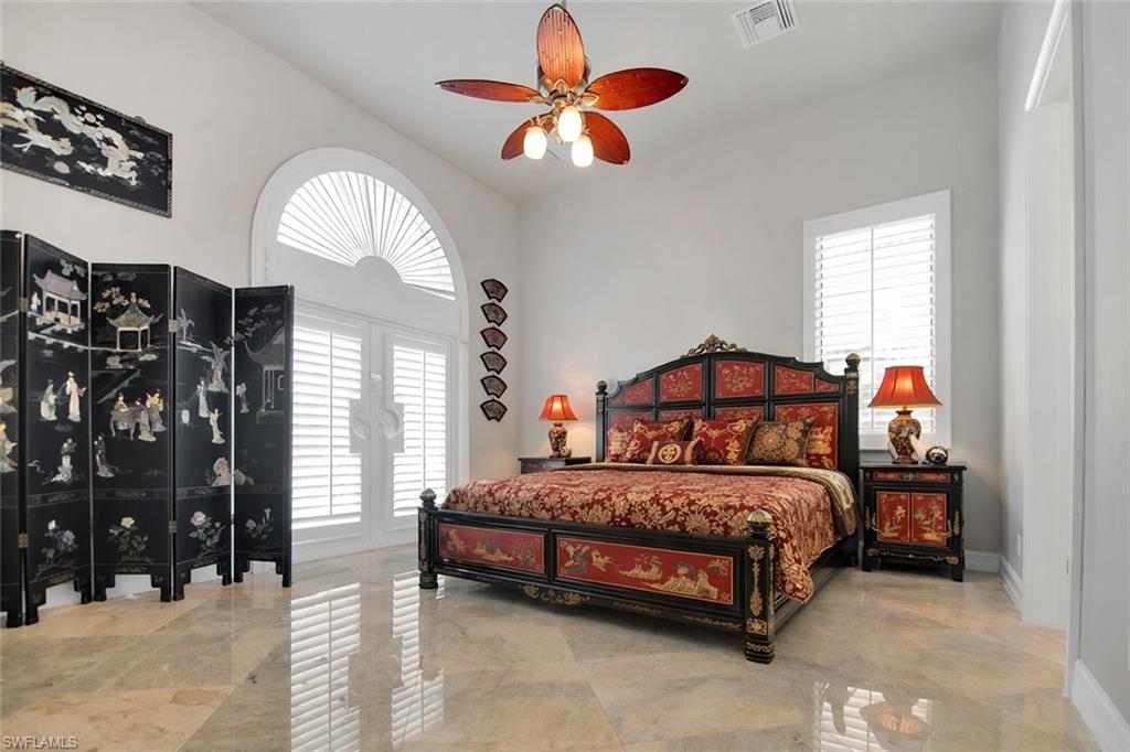 28 West Pelican Street Naples, FL 34113 - Photo 23 of 50 a bedroom with a bed and a chandelier