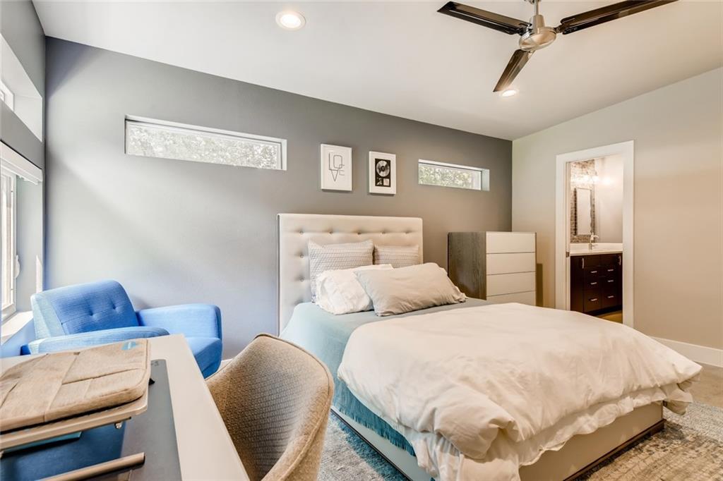 1142 Eleanor Street, Unit 2 Austin, TX 78721 - Photo 12 of 24 A tranquil primary bedroom features clean lines, a ceiling fan, and seamless access to an adjoining bathroom.