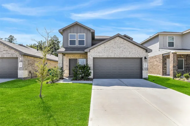 a front view of a house with a yard and garage