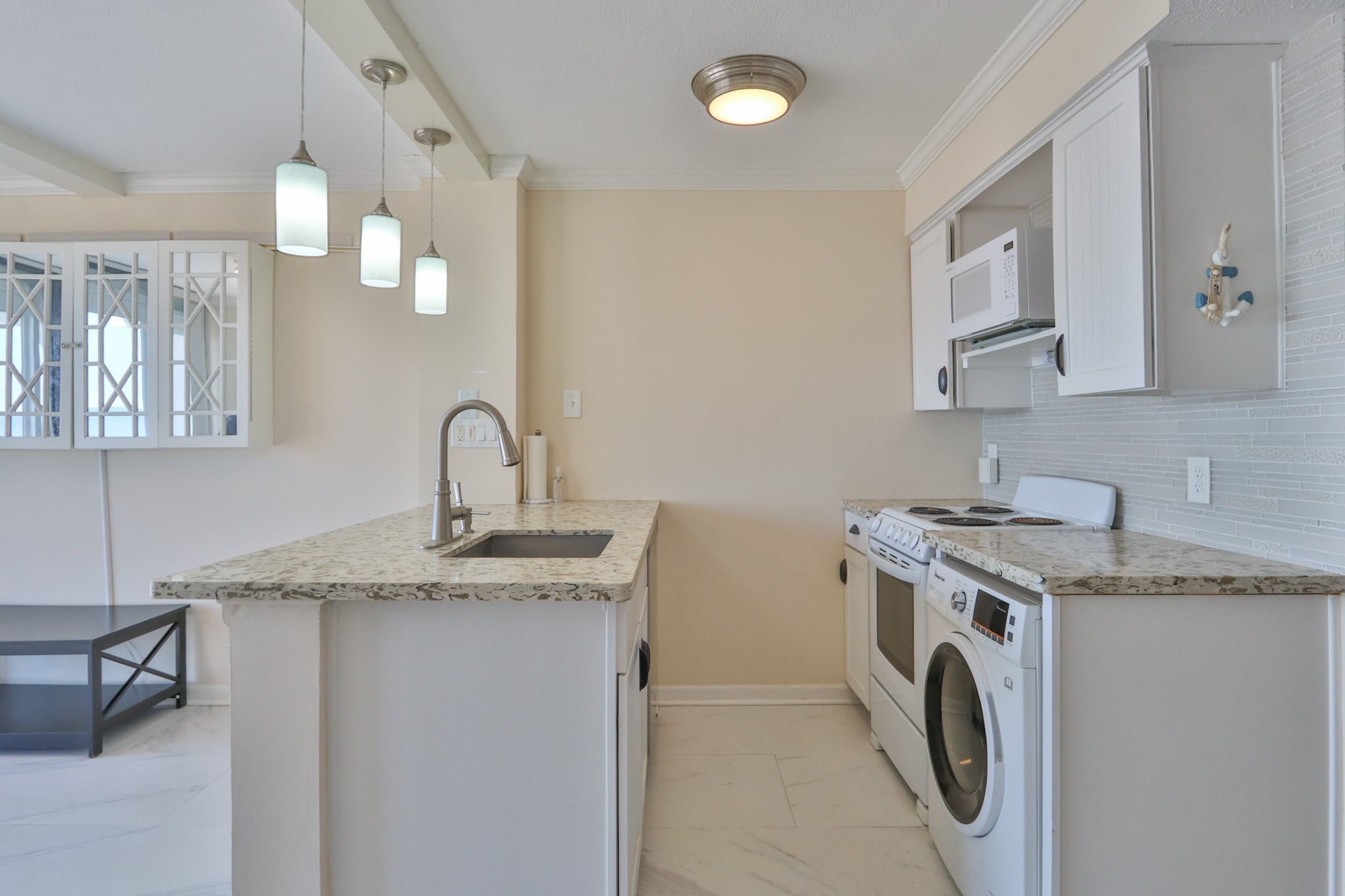 11949 Termini-San Luis Pass Road, Unit 304 Galveston, TX 77554 - Photo 9 of 39 The kitchen offers beautiful countertops, upgraded cabinets and pendent lights. It even has a washer/dryer combo for your convenience!