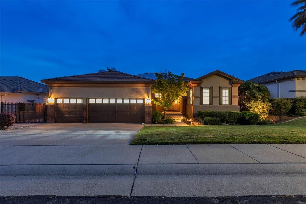 a view of a house with a yard and table and chairs under an umbrella